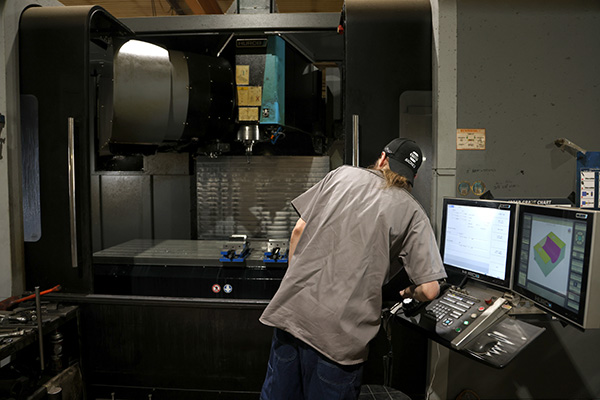 Worker operating CNC mill