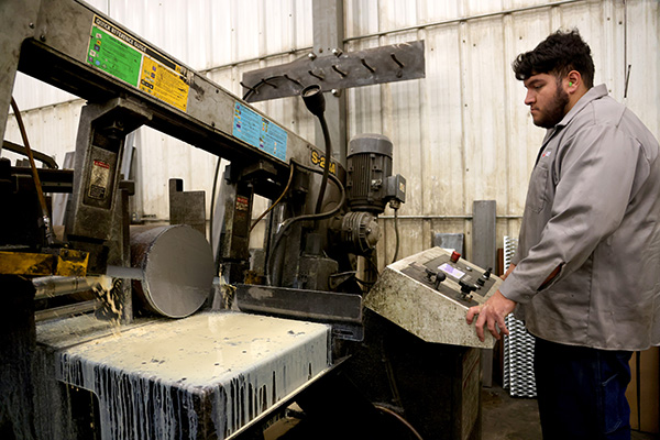 Worker operating steel saw