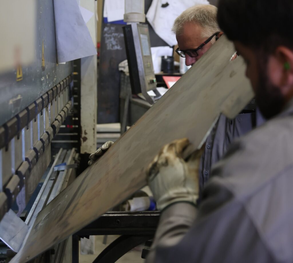 Workers operating CNC Press Brake